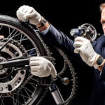 An image featuring a close-up shot of a gloved hand delicately unscrewing the governor from an electric bike's motor, revealing the intricate internal wiring and components