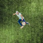 aerial view of man playing soccer ball on grass