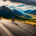 An image showcasing a rugged gravel road winding endlessly through breathtaking mountainous terrain, with determined cyclists pushing their limits as they race against time in the ultimate test of endurance